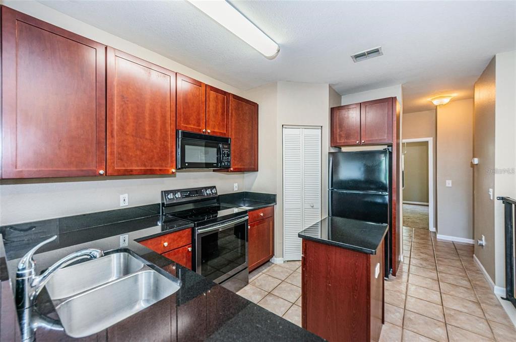 2254 Chianti Place, Unit 66 Palm Harbor, FL 34683 - Photo 6 of 20 a kitchen with stainless steel appliances granite countertop a stove a refrigerator and a sink