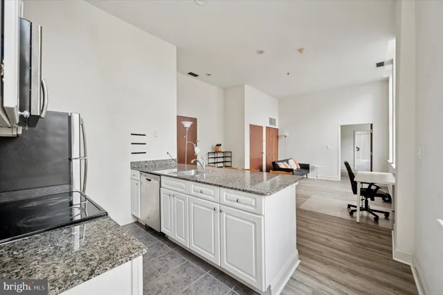 a kitchen with granite countertop a sink and a stove top oven