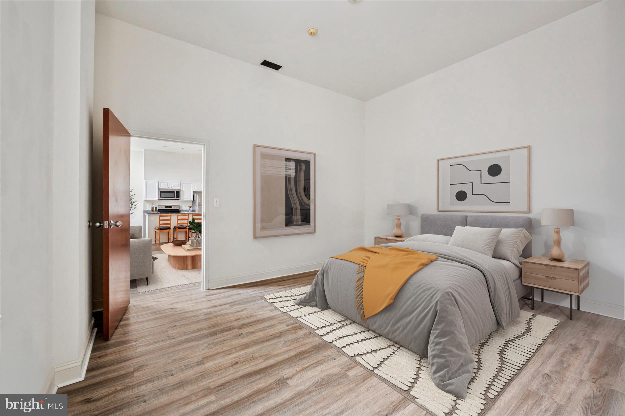 1001 Chestnut Street, Unit 904W Philadelphia, PA 19103 - Photo 14 of 25 a bedroom with a large bed and a wooden floor