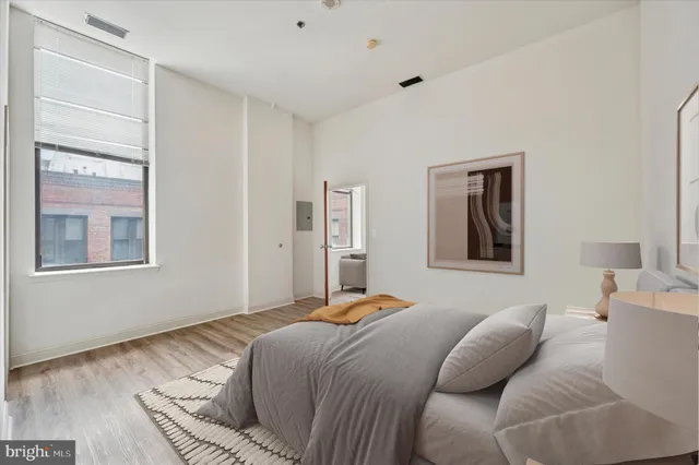 a bedroom with a bed and wooden floor