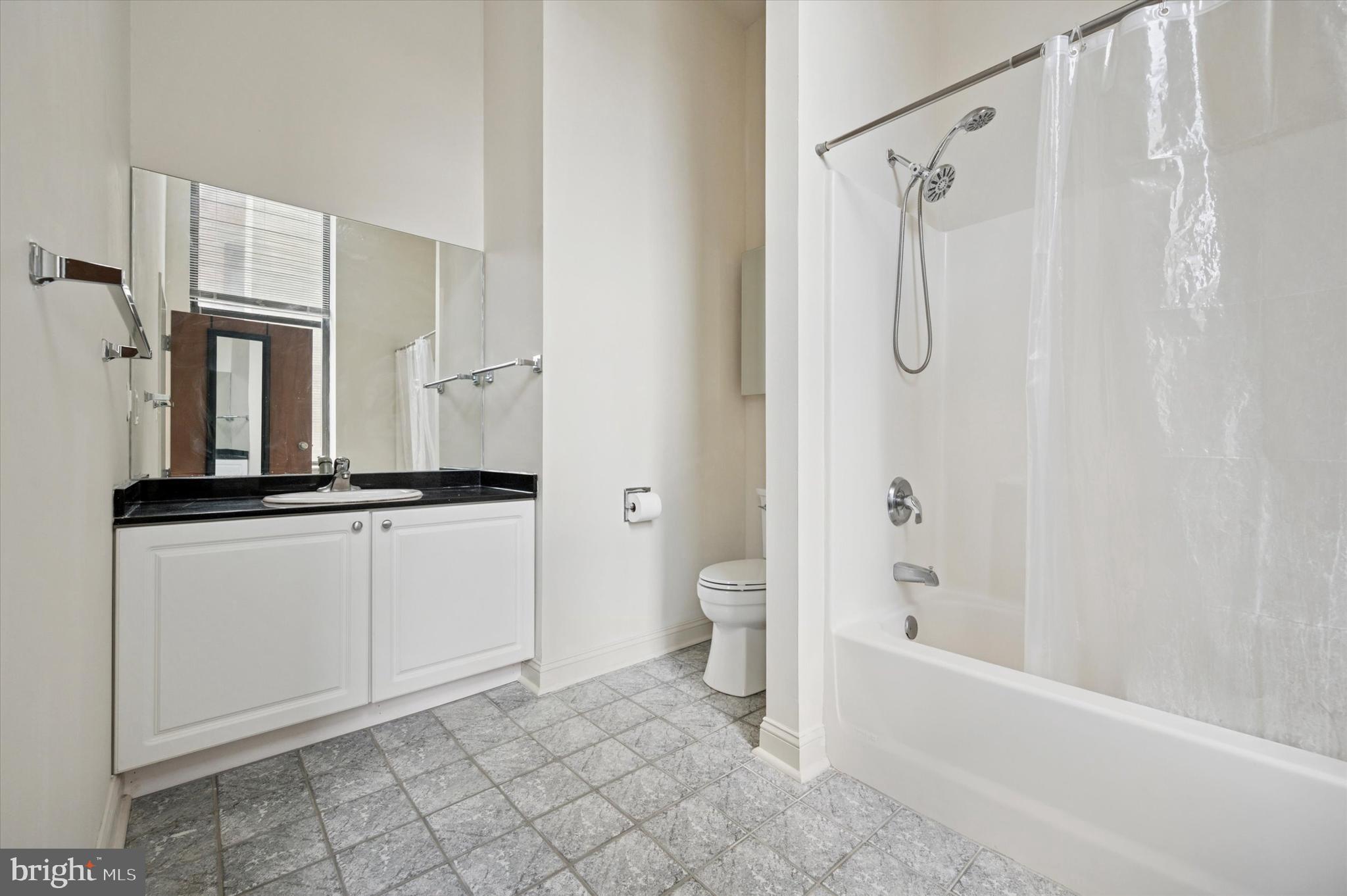 1001 Chestnut Street, Unit 904W Philadelphia, PA 19103 - Photo 22 of 25 a bathroom with a double vanity sink a mirror and a bathtub