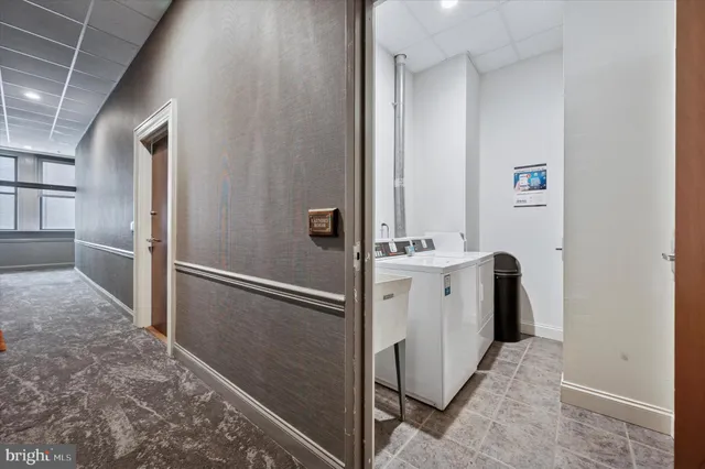 a view of a hallway with white cabinets