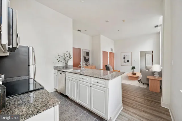 a spacious bathroom with a granite countertop sink and a mirror