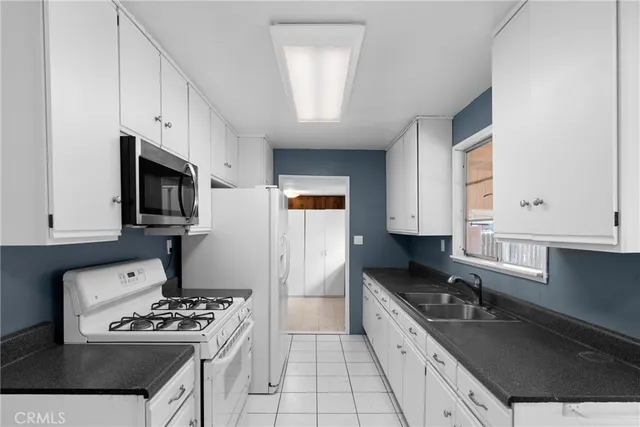 a kitchen with granite countertop a sink cabinets and window
