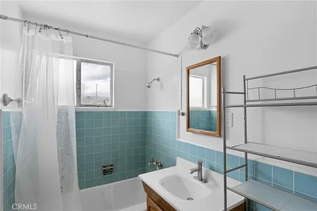 a view of an empty room with window and a ceiling fan