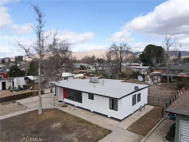 a view of a big house with a big yard and large tree