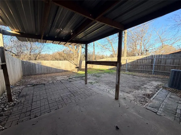 a view of empty room with wooden floor and iron fence