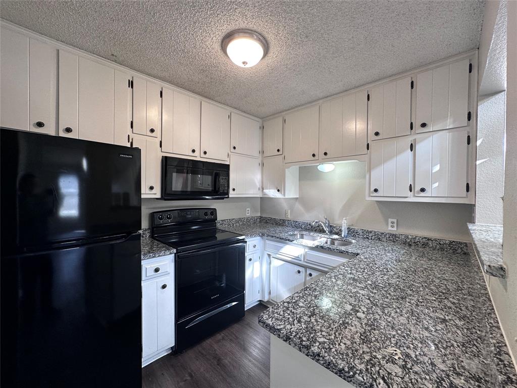 1110 B Lynn Street Weatherford, TX 76086 - Photo 3 of 8 a kitchen with granite countertop a refrigerator stove and microwave