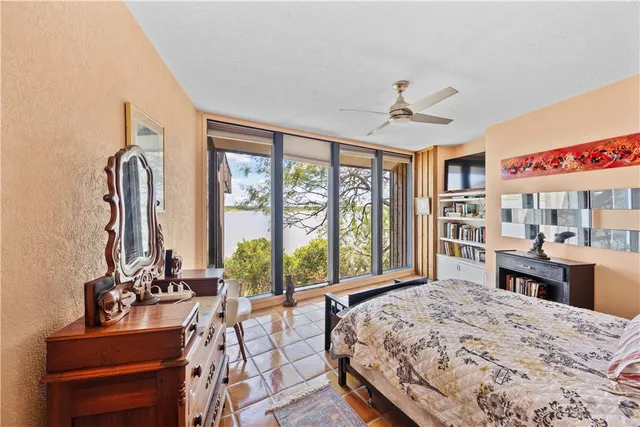 a bedroom with a bed and large windows