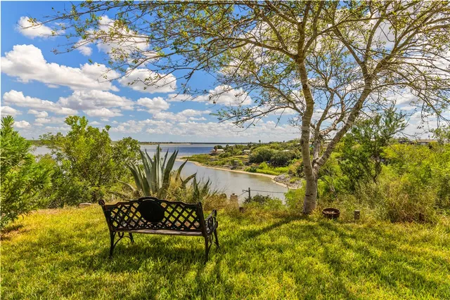 a view of a lake with table and chairs