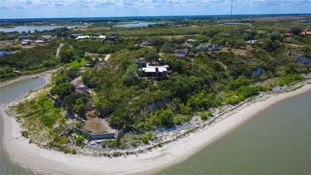 an aerial view of a house with a yard and lake view