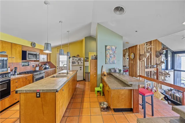 a kitchen with stainless steel appliances kitchen island granite countertop a refrigerator and stove