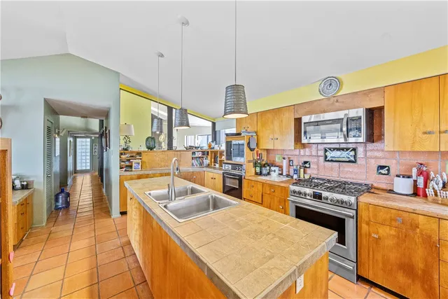 a kitchen with a sink a counter top space and stainless steel appliances