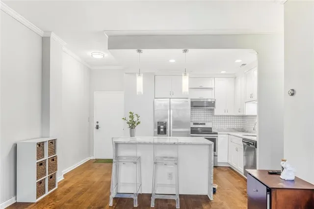 a kitchen with white cabinets and counter space