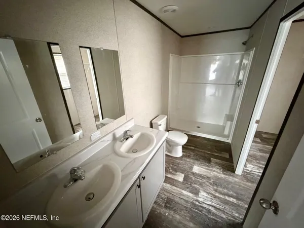 a bathroom with a double vanity sink and mirror with shower