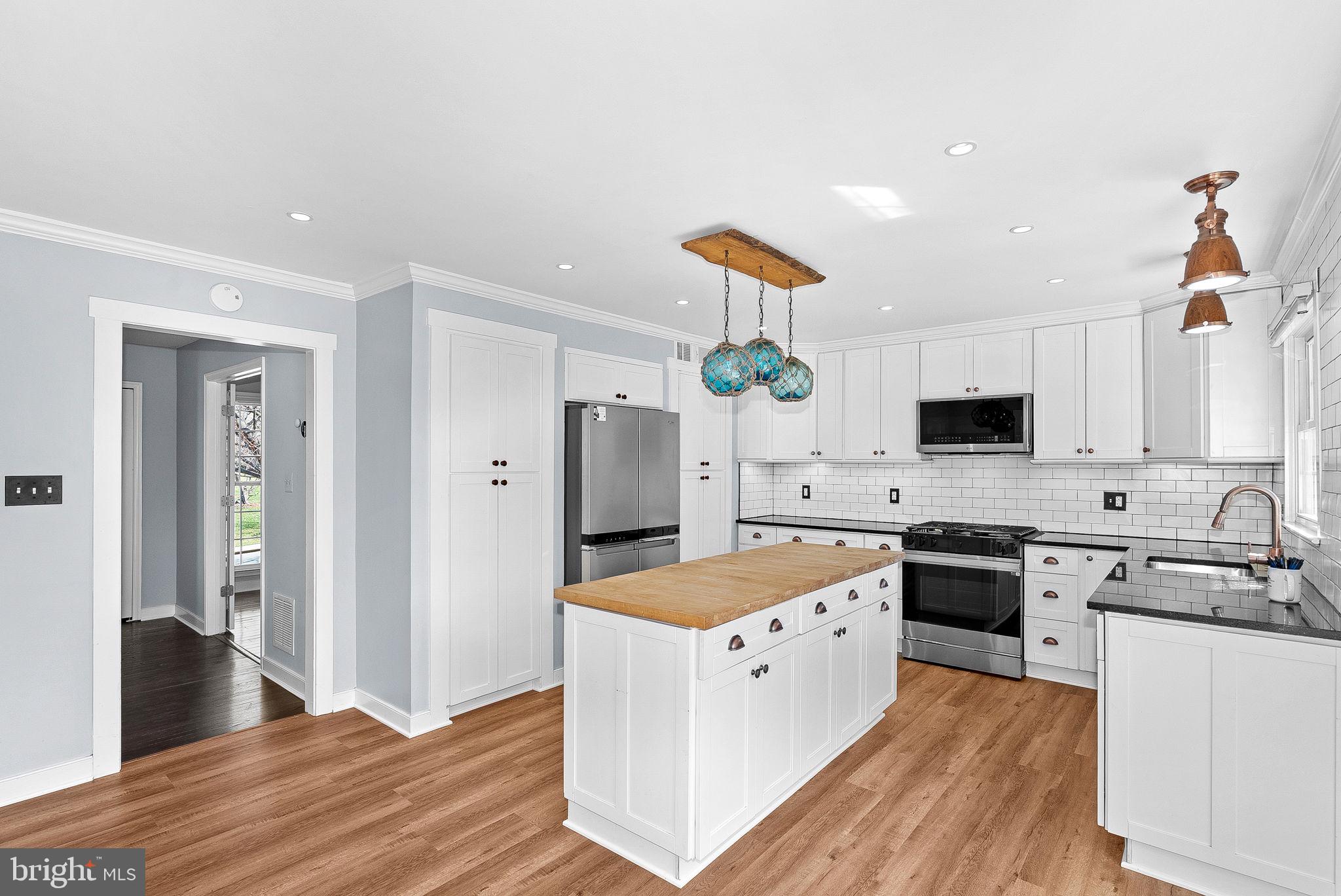 105 Country Road Sterling, VA 20165 - Photo 14 of 49 a large kitchen with stainless steel appliances granite countertop a stove a sink dishwasher and a refrigerator with wooden floor