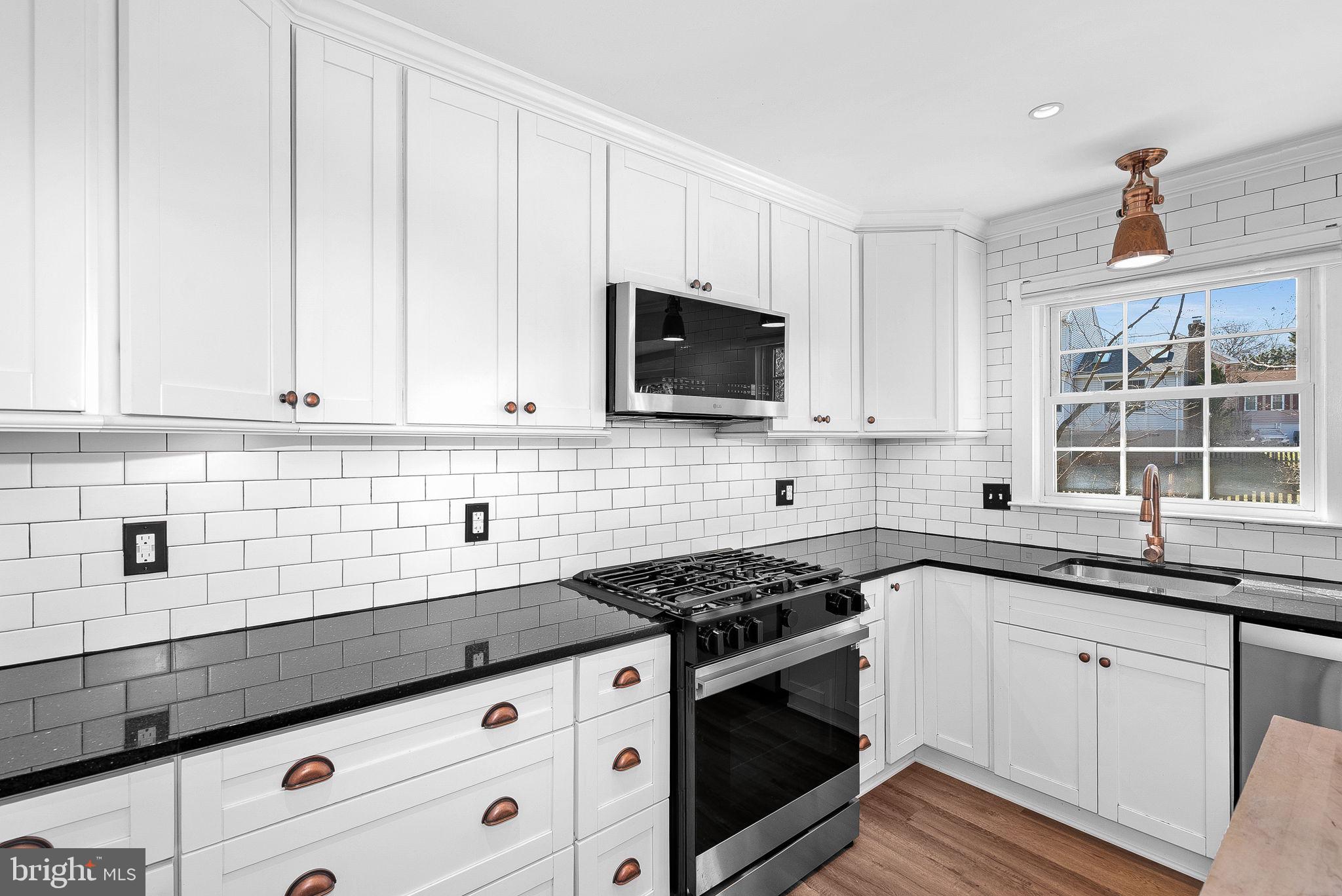 105 Country Road Sterling, VA 20165 - Photo 17 of 49 a kitchen with granite countertop white cabinets and black appliances
