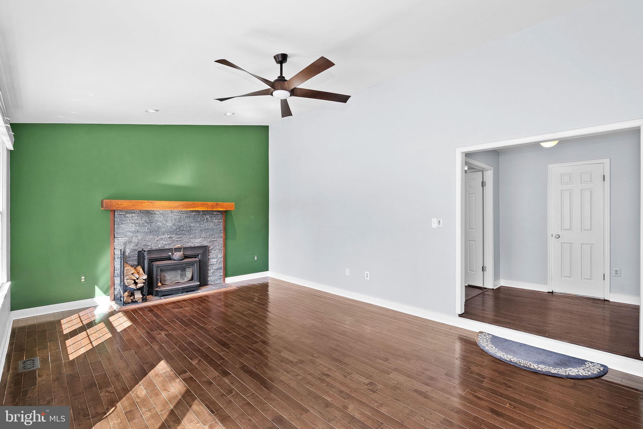 105 Country Road Sterling, VA 20165 - Photo 20 of 49 an empty room with wooden floor a fireplace and a window