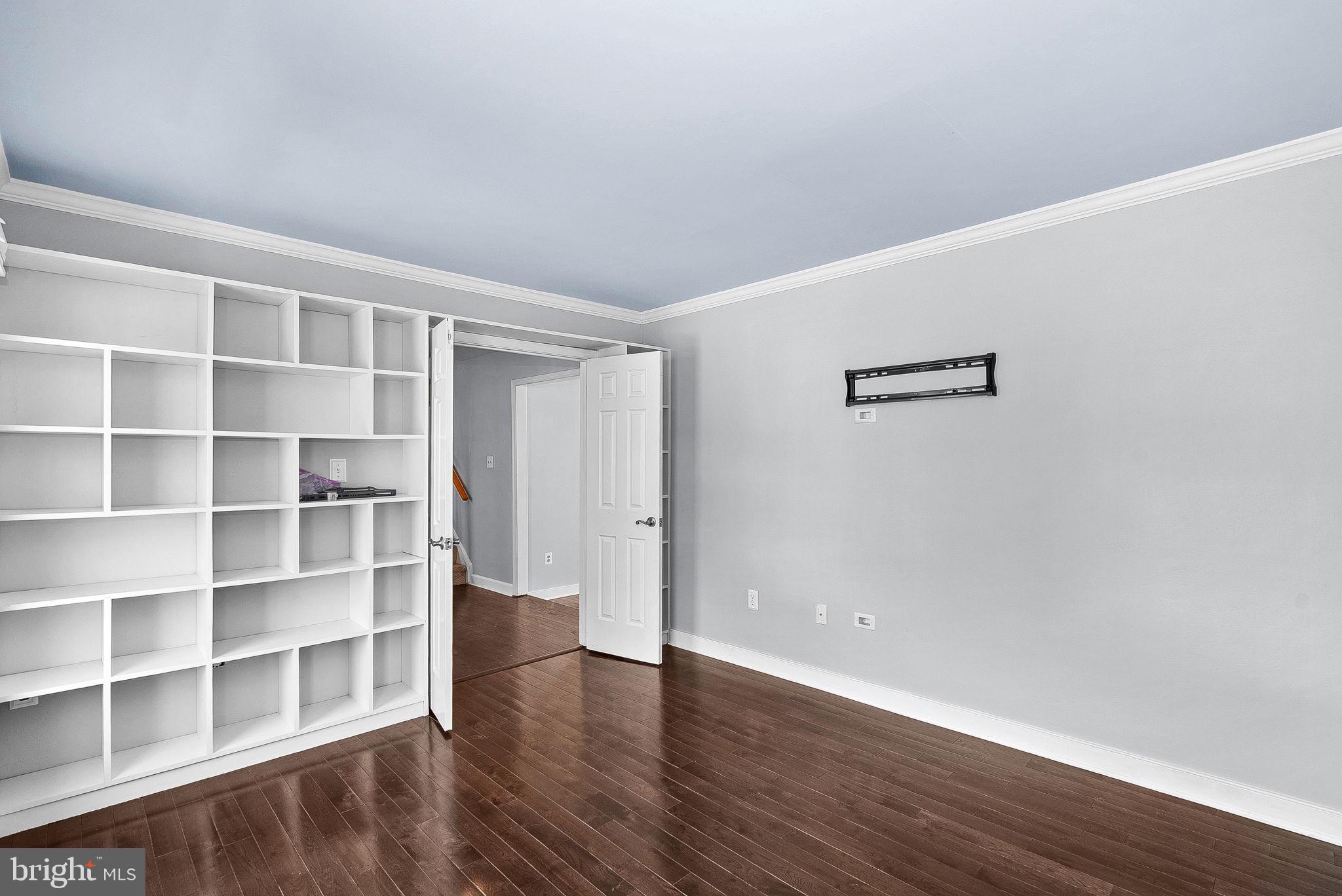 105 Country Road Sterling, VA 20165 - Photo 9 of 49 a view of an empty room with wooden floor and shelves