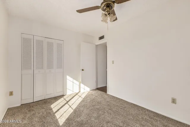a view of a room with a chandelier fan and wooden floor