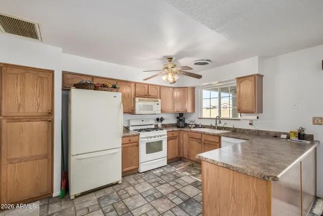 a kitchen with a sink a stove a refrigerator and white cabinets