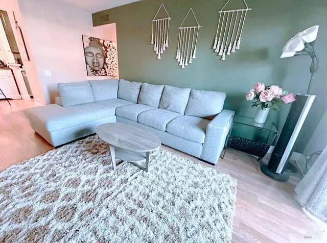 a living room with furniture and wooden floor