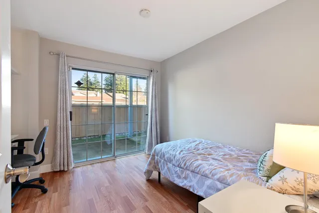 a big room with wooden floor and a kitchen