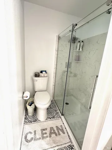 a bathroom with a toilet and a shower
