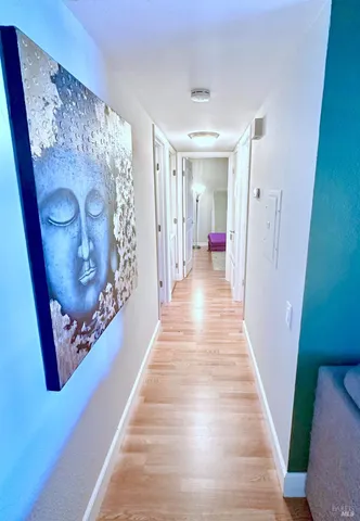 a view of a hallway with wooden floor and staircase
