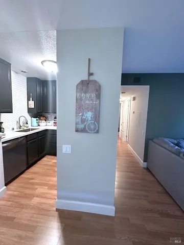 a kitchen with stainless steel appliances granite countertop a refrigerator a sink dishwasher and a stove with wooden floor