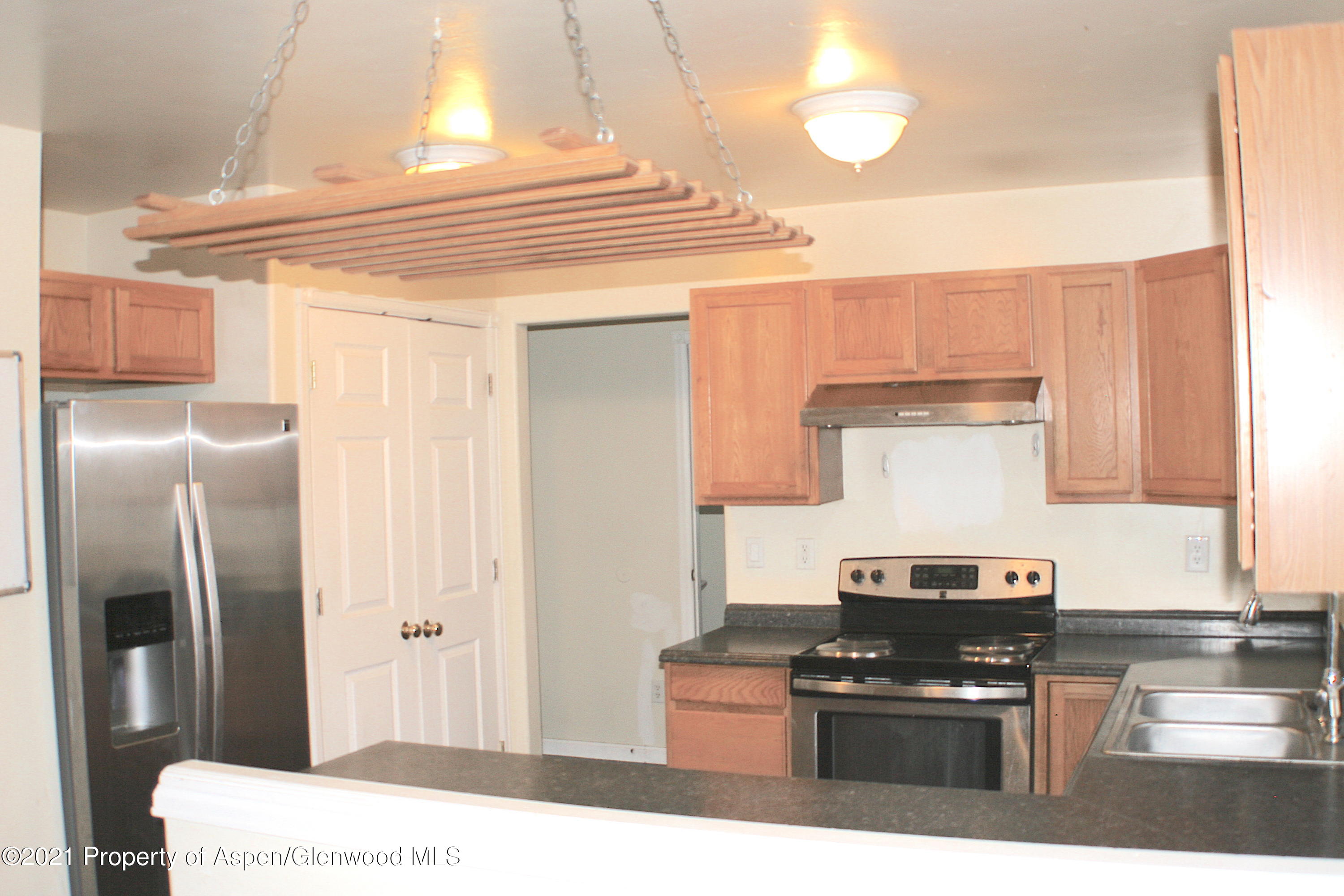 3169 West 31st Court Rifle, CO 81650 - Photo 7 of 27 a kitchen with stainless steel appliances granite countertop a stove a refrigerator and a microwave