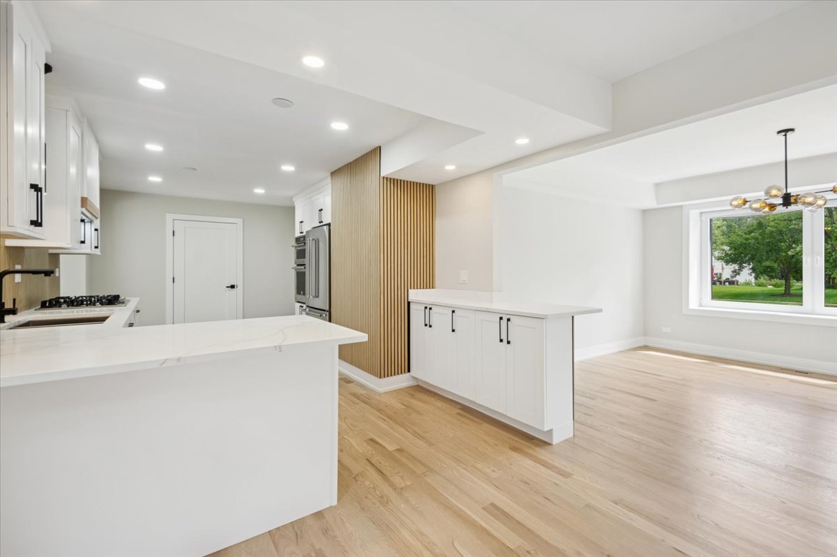 303 Cedarbrook Road Naperville, IL 60565 - Photo 11 of 30 a view of kitchen with stainless steel appliances kitchen island wooden floors granite counter tops and a stove