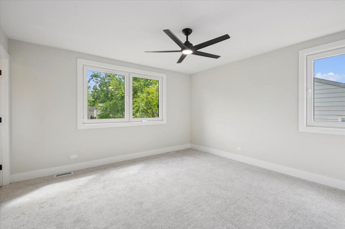 303 Cedarbrook Road Naperville, IL 60565 - Photo 21 of 30 a view of a big room with a window and a fan