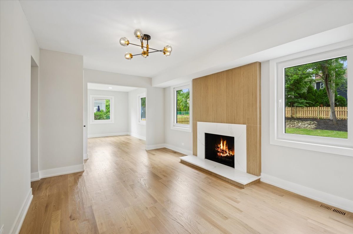 303 Cedarbrook Road Naperville, IL 60565 - Photo 6 of 30 a view of a livingroom with wooden floor a fireplace and windows