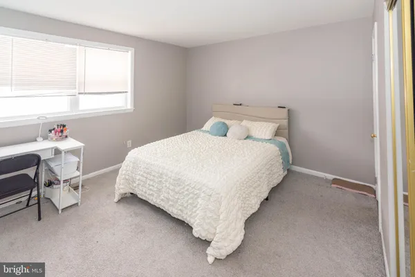 a bedroom with a bed chair and window