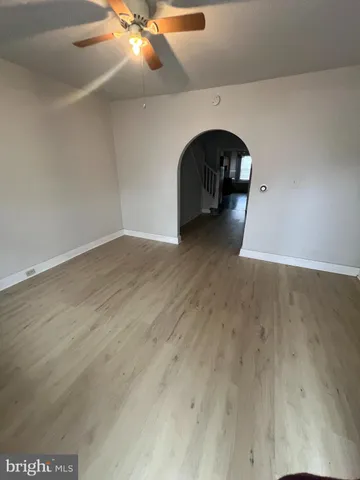 a view of a livingroom with wooden floor and a ceiling fan