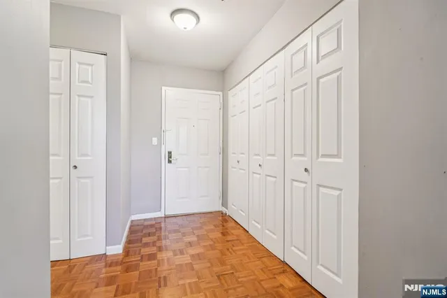 a view of a hallway with wooden floor and closet area