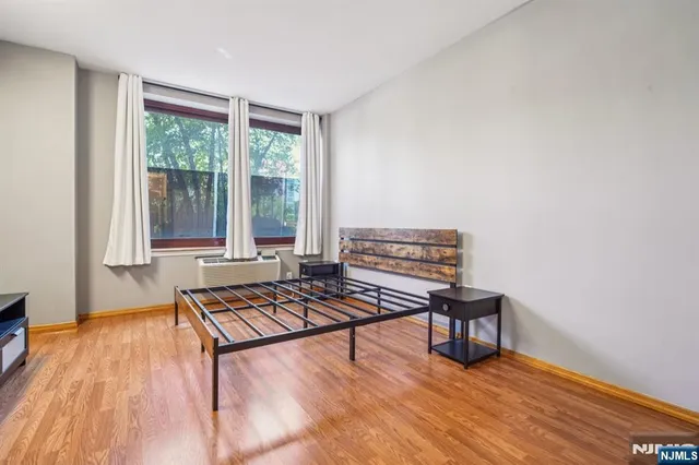 a living room with furniture a wooden floor and next to a window