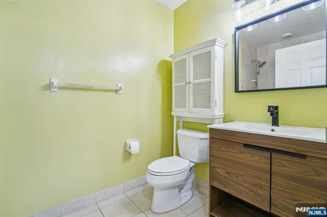 a bathroom with a granite countertop toilet sink and mirror