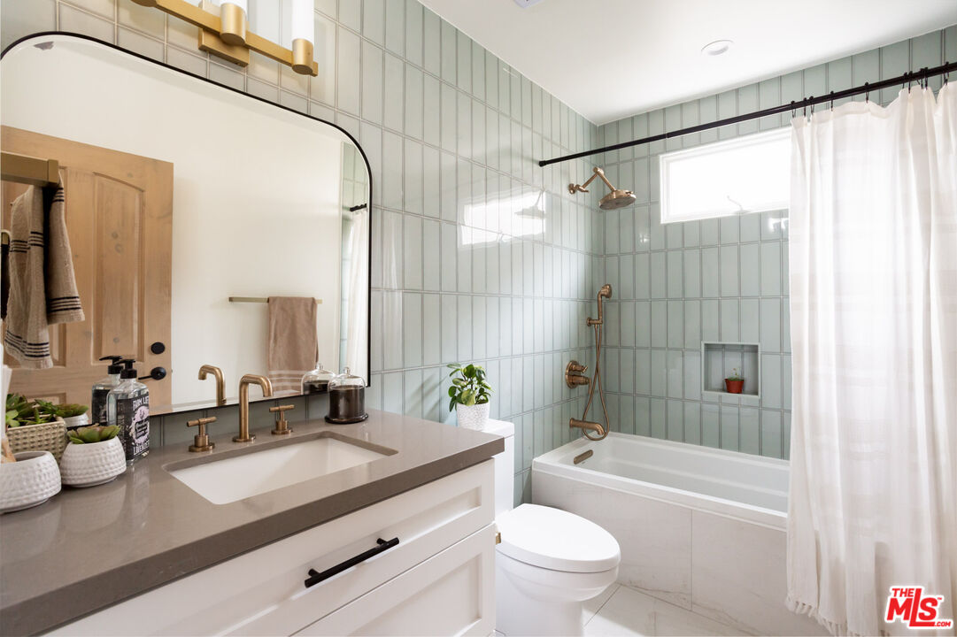 7137 Trask Avenue Playa del Rey, CA 90293 - Photo 9 of 46 a bathroom with a granite countertop sink a toilet and shower