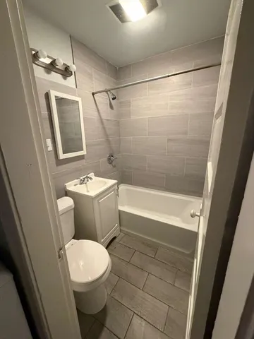 a white toilet sitting next to a bath tub