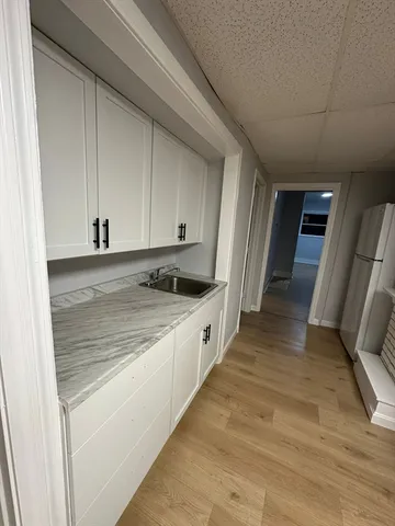 a large white kitchen with granite countertop sink