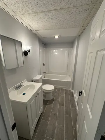 a bathroom with a tub sink toilet and mirror