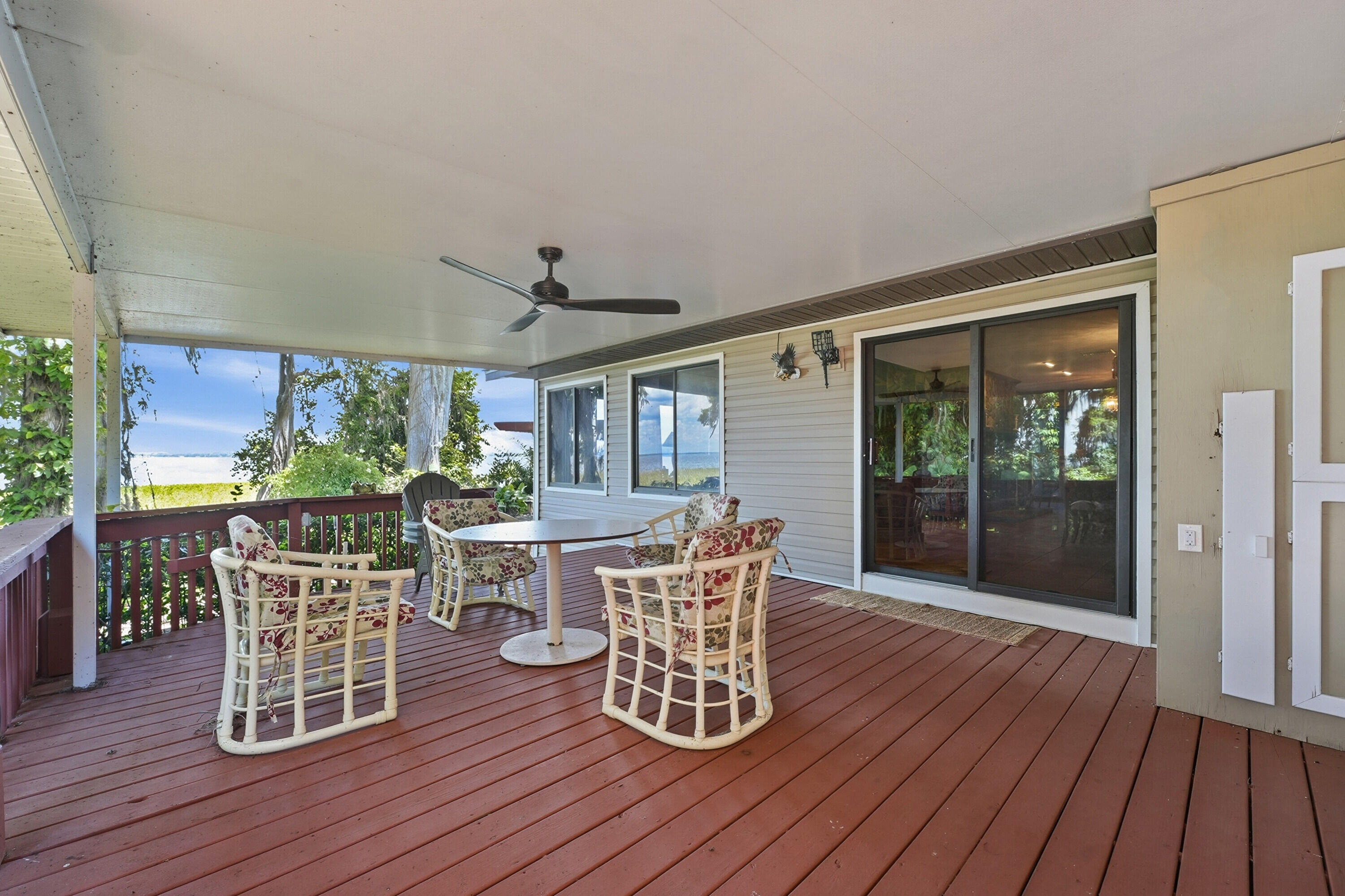 200 Windy Point Road Lake Placid, FL 33852 - Photo 44 of 74 a view of a roof deck with table and chairs a barbeque with wooden floor and floor to ceiling window