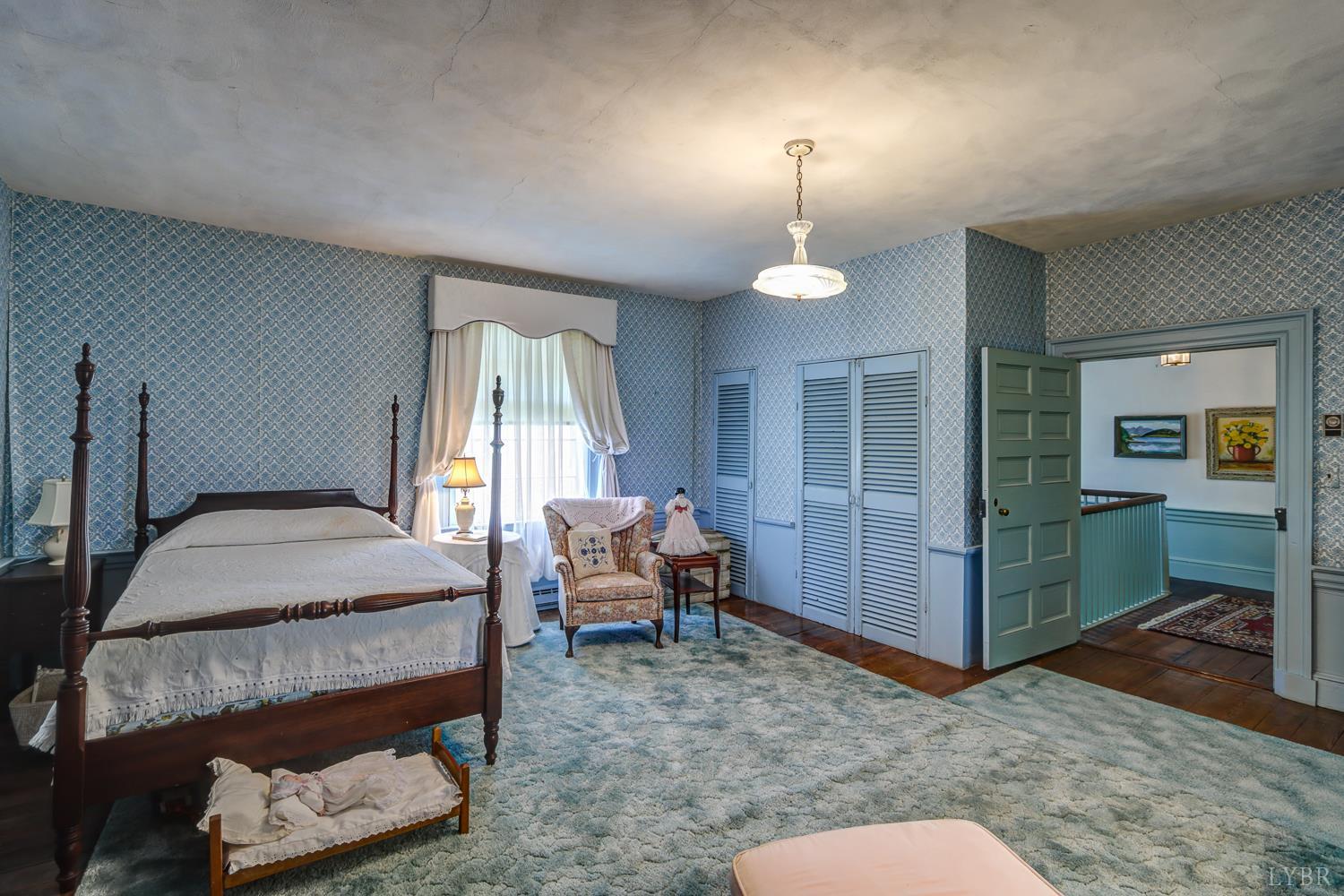 129 Lawyers Road Red House, VA 23963 - Photo 45 of 72 a bedroom with a bed and a chandelier
