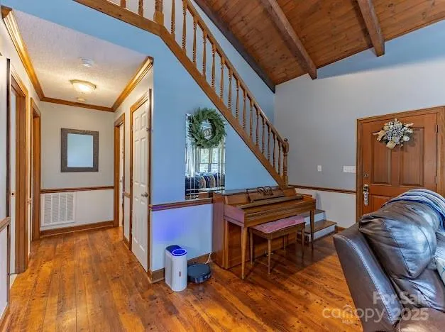 a living room with furniture stairs and a wooden floor