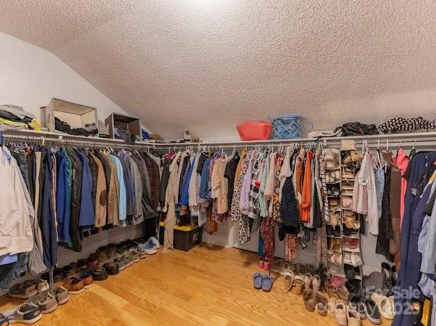 a view of walk in closet with clothes