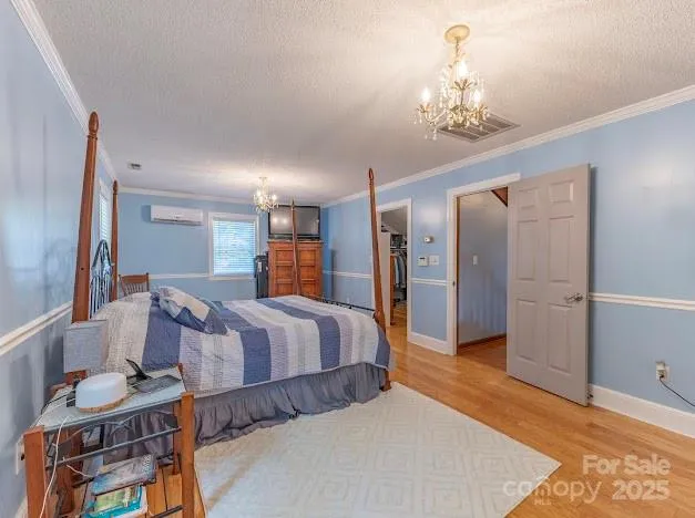 a spacious bedroom with a bed and a chandelier