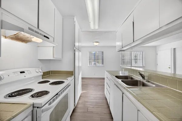 a kitchen that has a sink a stove and cabinets