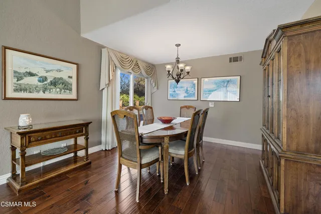 a view of a dining room with furniture a chandelier and wooden floor